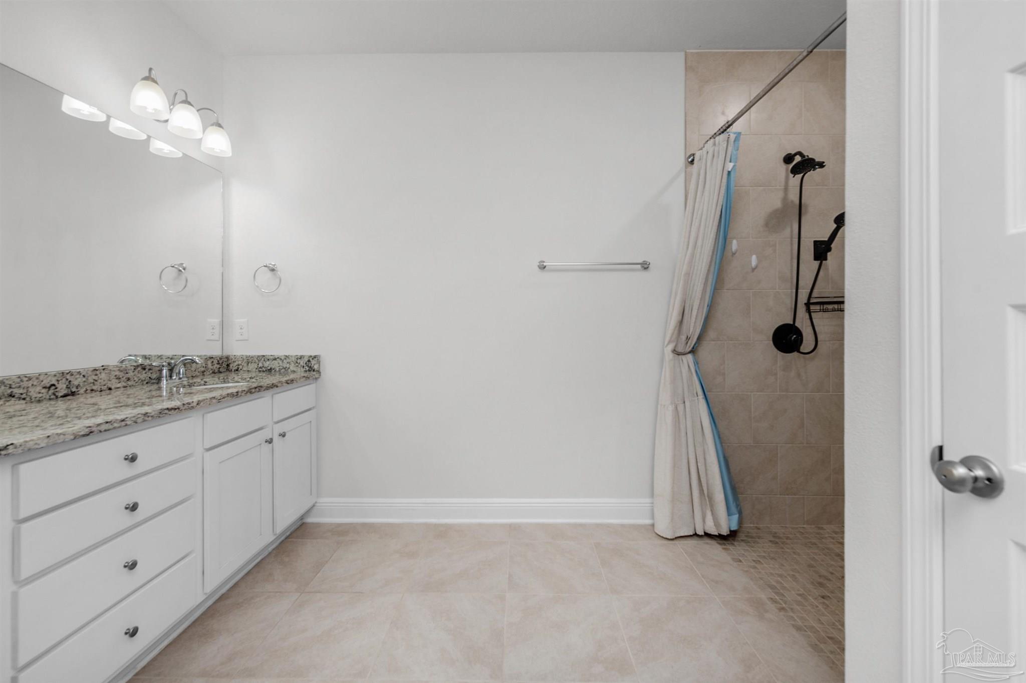 7814 Burnside Loop Pensacola, FL 32526 - Photo 32 of 41 a bathroom with a granite countertop sink a shower and a mirror