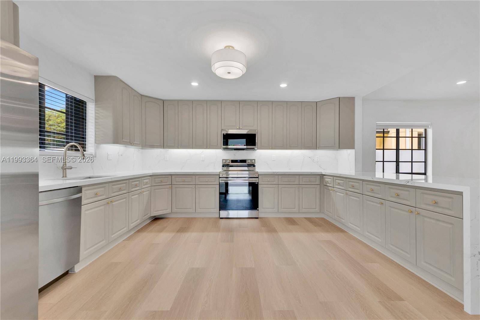 456 Southwest 20th Road, Unit 458 Miami, FL 33129 - Photo 7 of 37 a kitchen with granite countertop white cabinets and stainless steel appliances