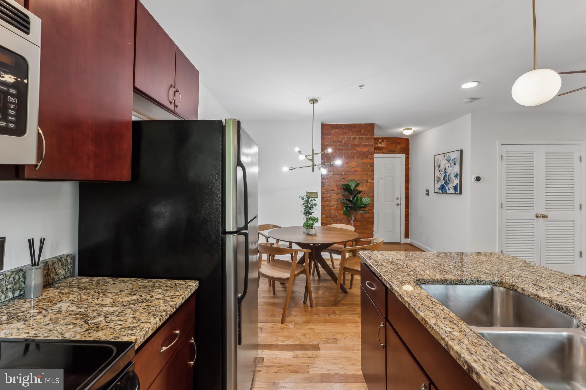 5403 9th Street Northwest, Unit 204 Washington, DC 20011 - Photo 6 of 19 a kitchen with granite countertop a sink a counter top stainless steel appliances and cabinets