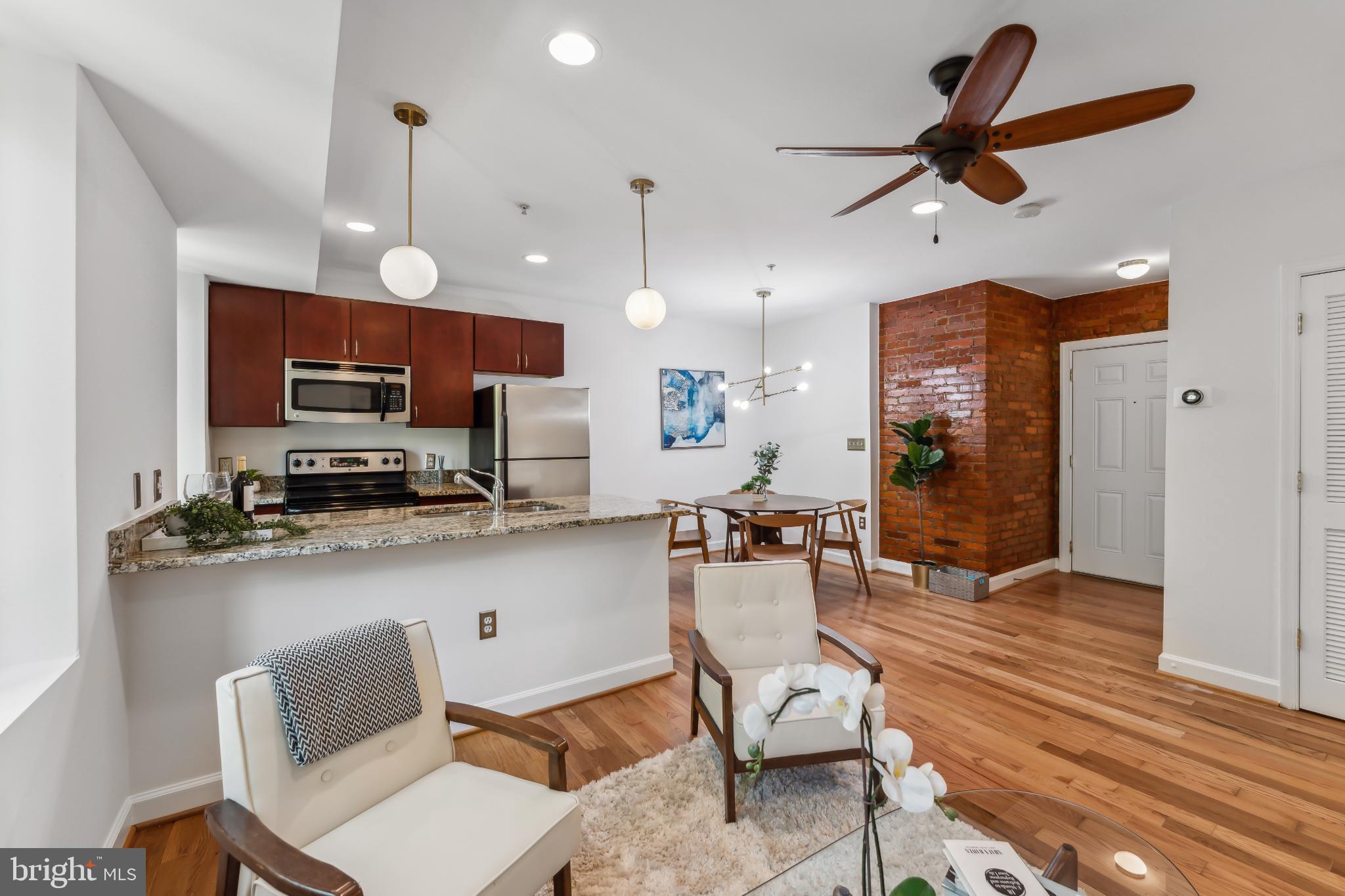 5403 9th Street Northwest, Unit 204 Washington, DC 20011 - Photo 10 of 19 a kitchen with stainless steel appliances kitchen island granite countertop a refrigerator a stove top oven a sink and dishwasher