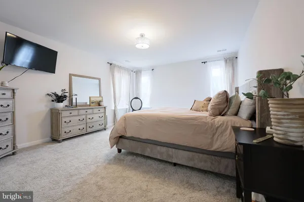 a spacious bedroom with a bed and a flat screen tv