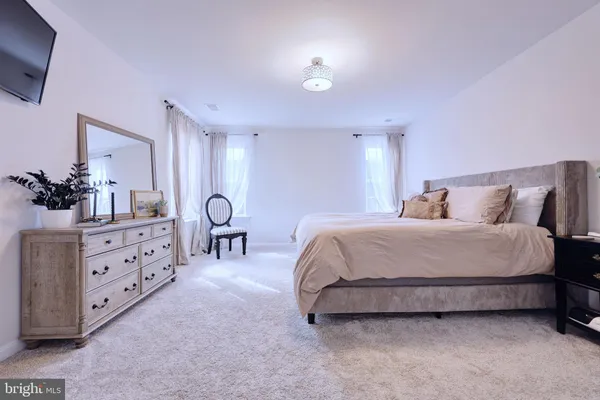 a spacious bedroom with a bed and a dresser