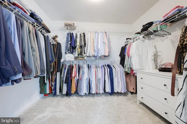 a view of walk in closet with clothes