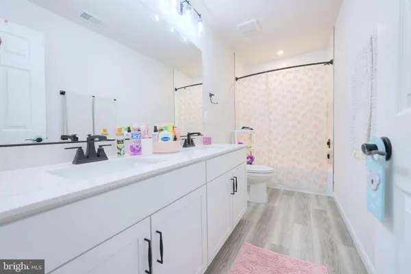 a bathroom with a sink and mirror with toilet