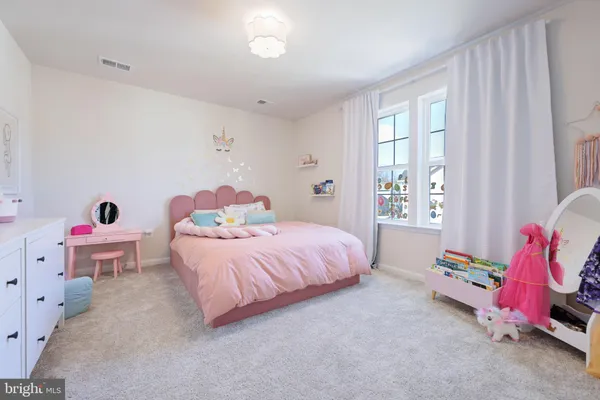 a spacious bedroom with a bed and a window