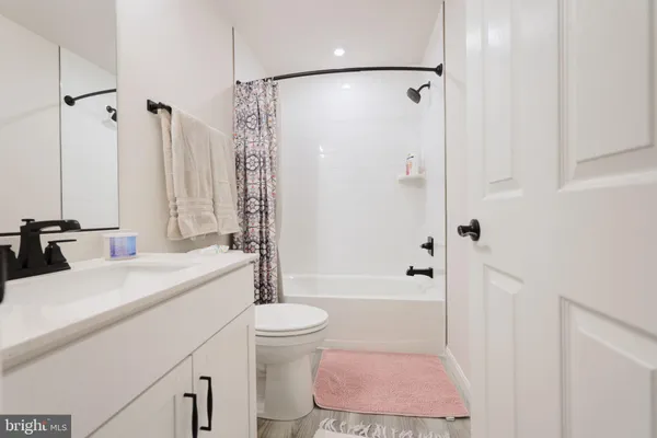 a bathroom with a sink a toilet a mirror and shower