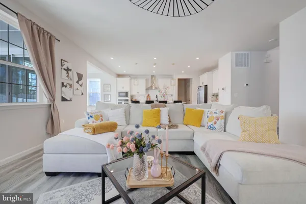 a living room with furniture and a kitchen view