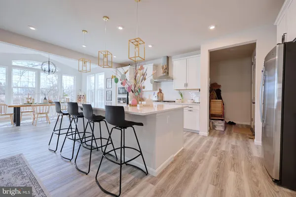 a kitchen with stainless steel appliances kitchen island hardwood floor and a sink