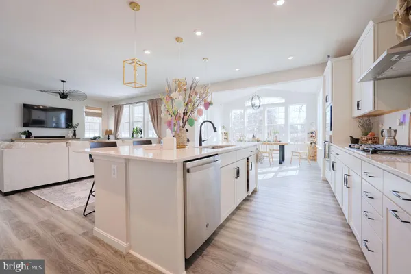 a large kitchen with stainless steel appliances kitchen island granite countertop a large counter top and a stove