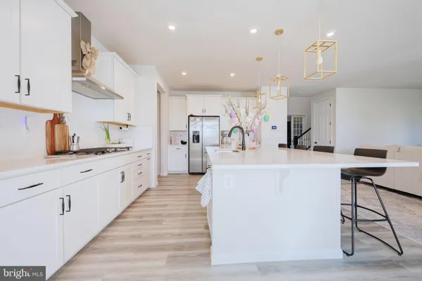 a large white kitchen with kitchen island a sink a stove and a refrigerator