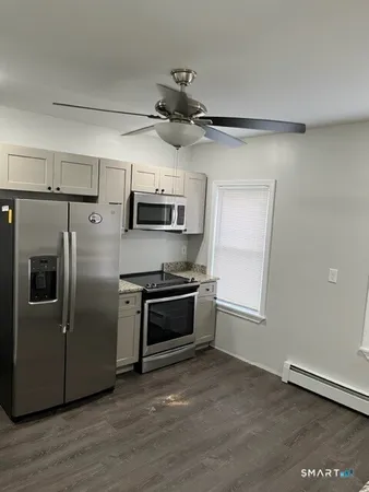 a kitchen with stainless steel appliances granite countertop a refrigerator a stove a sink and a microwave