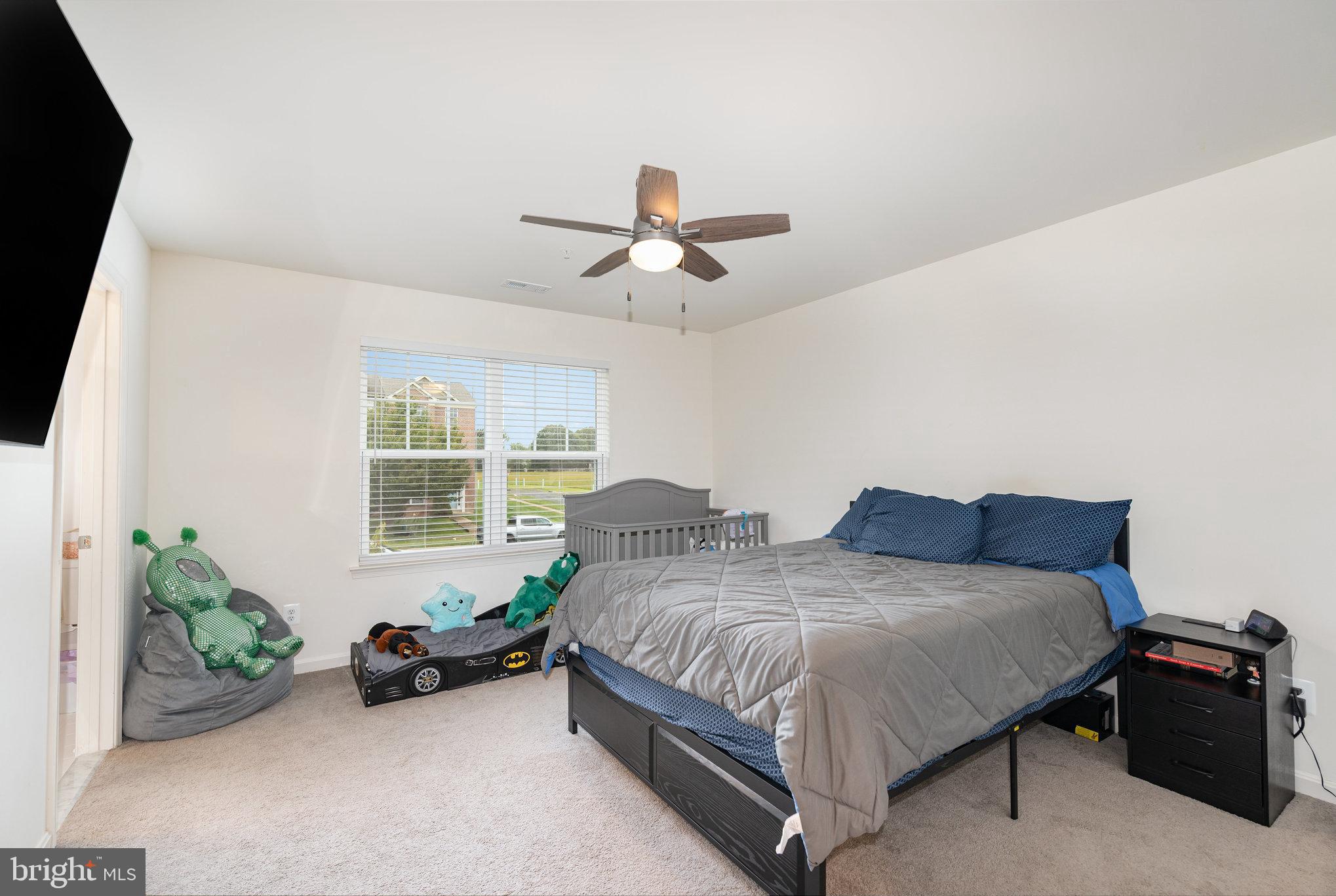 105 Maple Leaf Drive Rising Sun, MD 21911 - Photo 13 of 31 a spacious bedroom with two beds and a chandelier