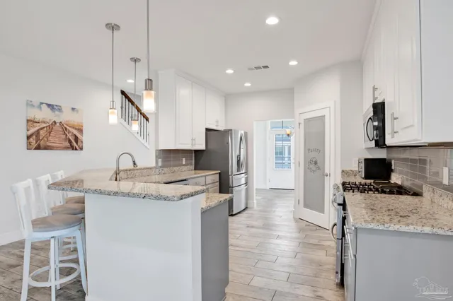 a kitchen with stainless steel appliances granite countertop a stove a refrigerator and a microwave