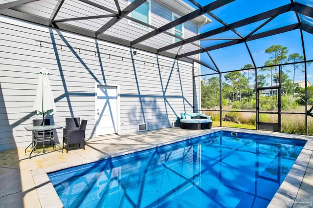 a view of a swimming pool with lawn chairs and plants