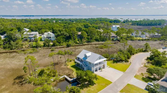 an aerial view of a city with lots of residential buildings ocean and mountain view in back