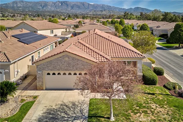 a front view of a house with a yard and potted plants