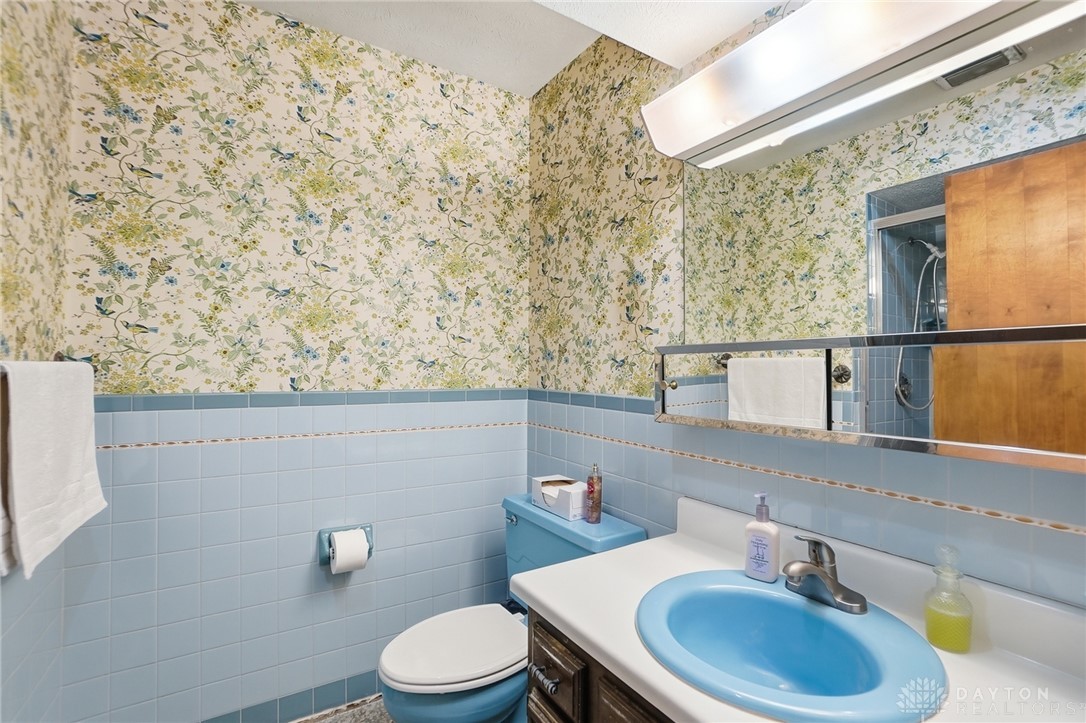 5669 O Neall Road Waynesville, OH 45068 - Photo 36 of 72 This bathroom features unique wallpaper and classic tiled walls, creating a distinctive aesthetic.