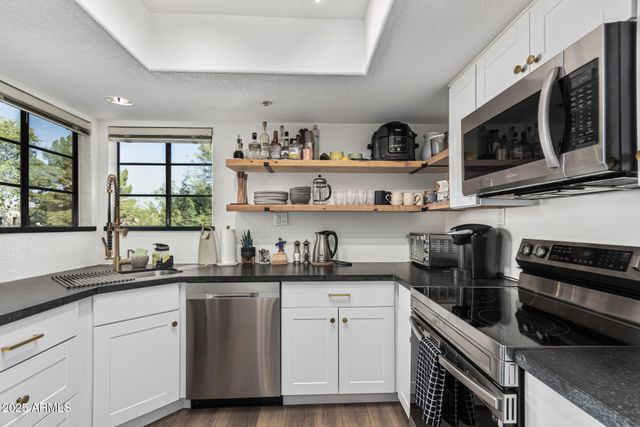 a kitchen with stainless steel appliances a sink stove and microwave