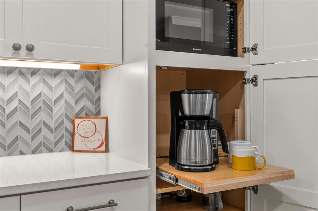 107 South Old Robinson Road Robinson, TX 76706 - Photo 13 of 39 Kitchen view of black microwave, white cabinetry, light stone counters, and tasteful backsplash
