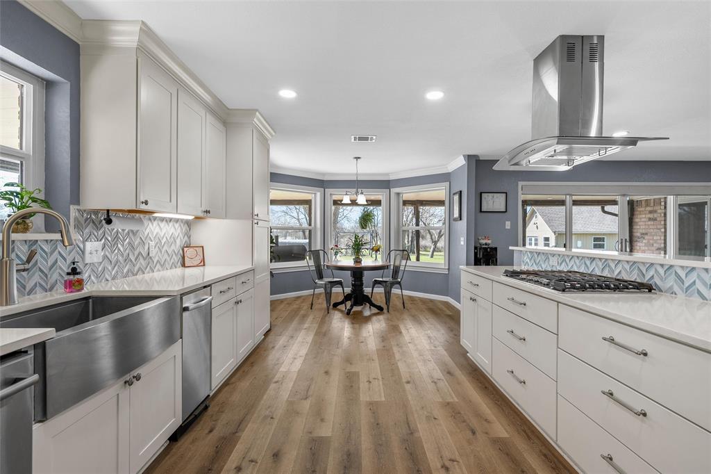 107 South Old Robinson Road Robinson, TX 76706 - Photo 15 of 39 Kitchen with tasteful backsplash, pendant lighting, island exhaust hood, light wood finished floors, and ornamental molding