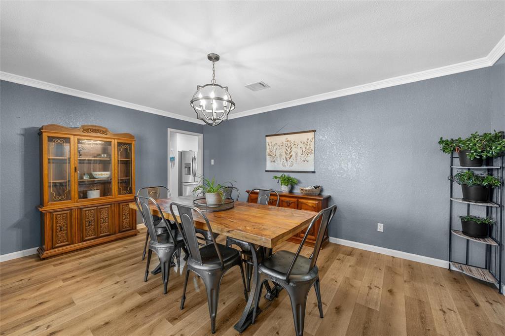 107 South Old Robinson Road Robinson, TX 76706 - Photo 17 of 39 Dining area featuring ornamental molding, a textured wall, light wood-type flooring, and suspended lighting