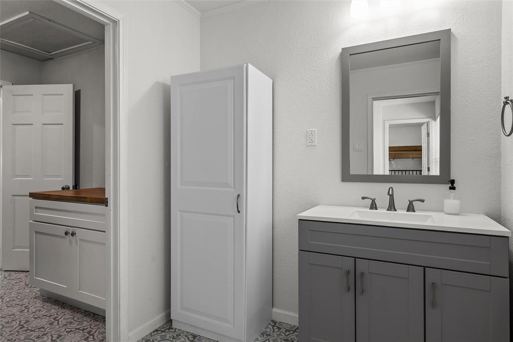 107 South Old Robinson Road Robinson, TX 76706 - Photo 29 of 39 Bathroom with two vanities, crown molding, and a textured wall