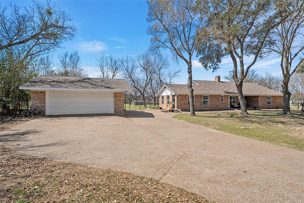 107 South Old Robinson Road Robinson, TX 76706 - Photo 4 of 39 View of side of home featuring an outdoor structure, brick siding, a garage, a chimney, and driveway