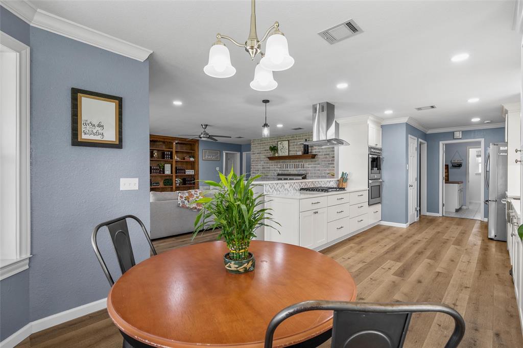 107 South Old Robinson Road Robinson, TX 76706 - Photo 9 of 39 Dining area with crown molding, light wood finished floors, ceiling fan, and suspended lighting