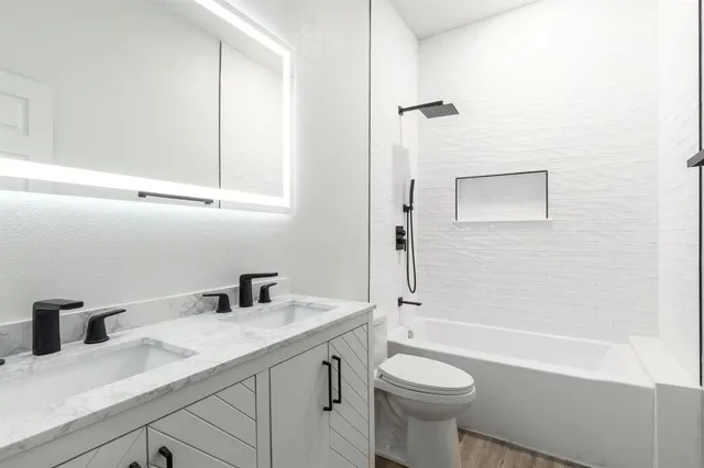 a bathroom with a sink a toilet and shower