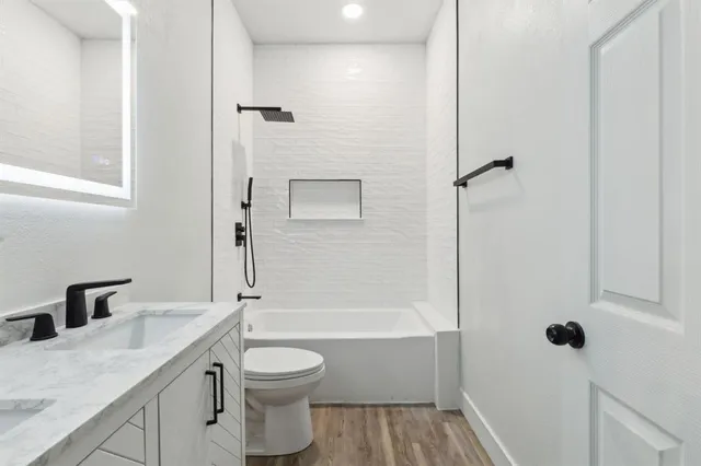 a bathroom with a sink a toilet and shower