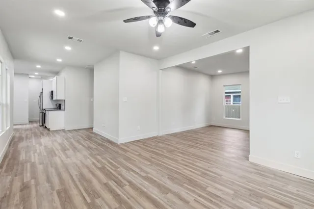 a view of empty room with wooden floor