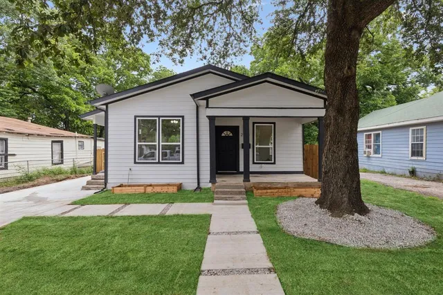 a front view of a house with a garden and yard