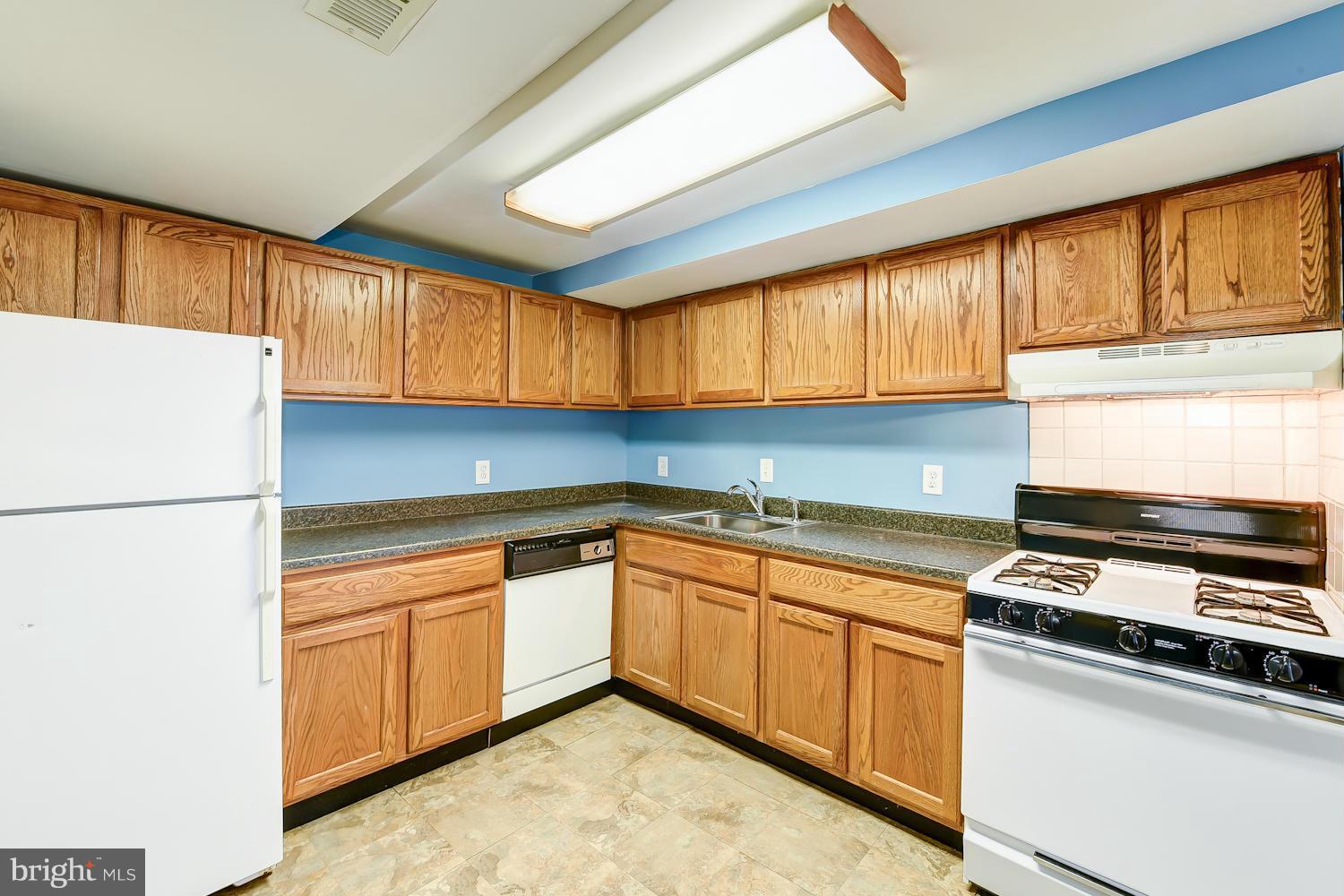 2360 Sun Valley Circle, Unit 2GH Silver Spring, MD 20906 - Photo 12 of 30 a kitchen with granite countertop a sink stainless steel appliances and cabinets