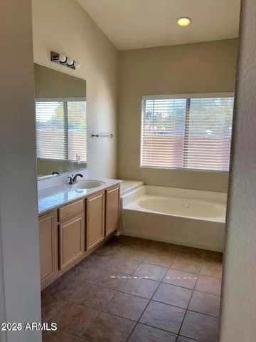 a bathroom with a tub sink and mirror