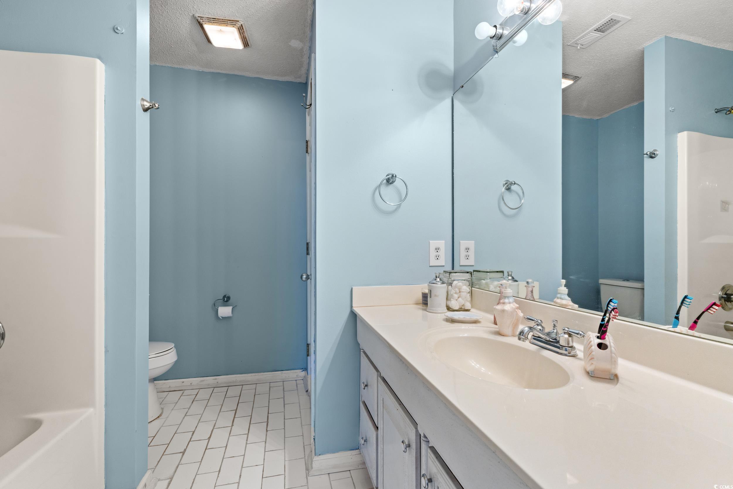 3471 Spivey Street Loris, SC 29569 - Photo 17 of 31 Full bathroom featuring vanity, toilet, a textured