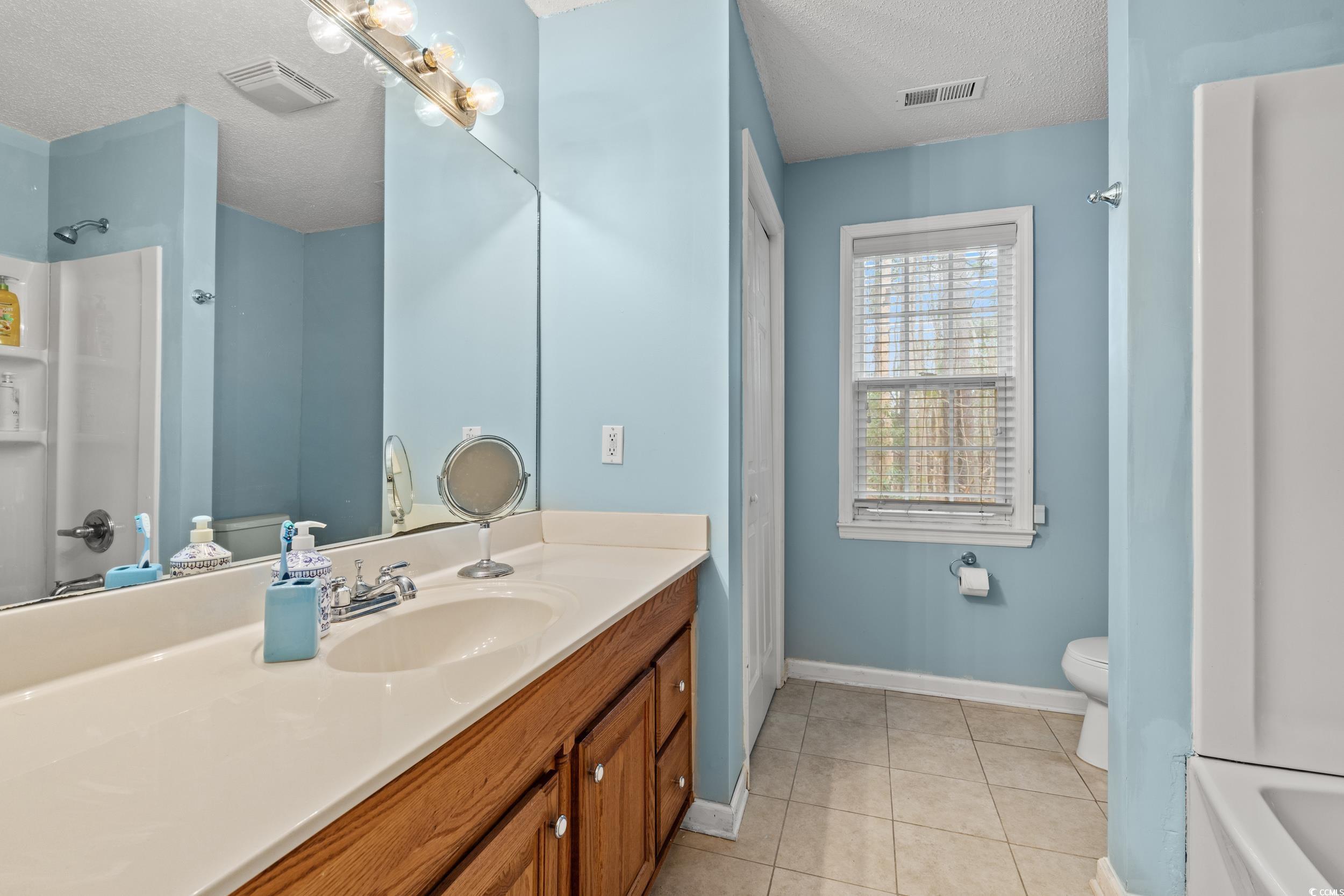 3471 Spivey Street Loris, SC 29569 - Photo 21 of 31 Bathroom with vanity, tile patterned floors, a tex