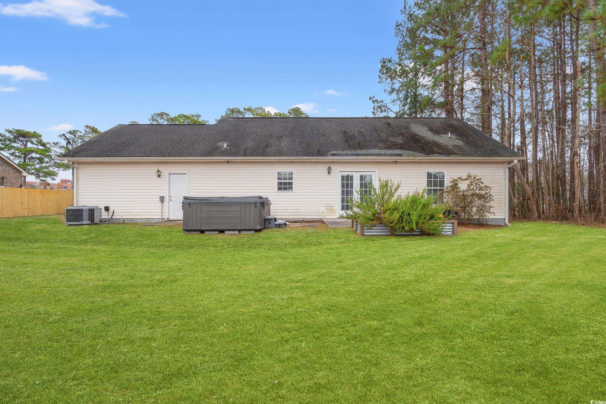 3471 Spivey Street Loris, SC 29569 - Photo 27 of 31 Back of house with a hot tub, a yard, and central