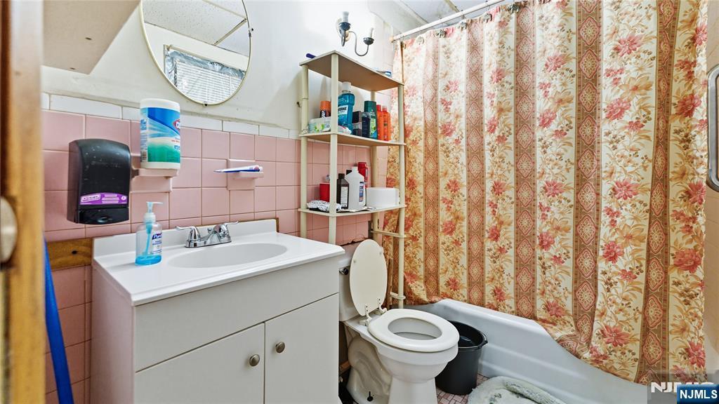 414 Market Street Paterson, NJ 07501 - Photo 7 of 9 a bathroom with a sink vanity mirror and toilet