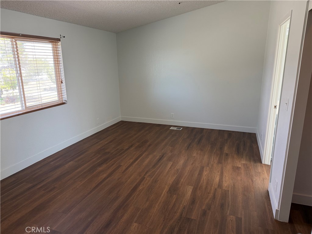 381 Amador Road Pinon Hills, CA 92372 - Photo 5 of 10 an empty room with wooden floor and windows