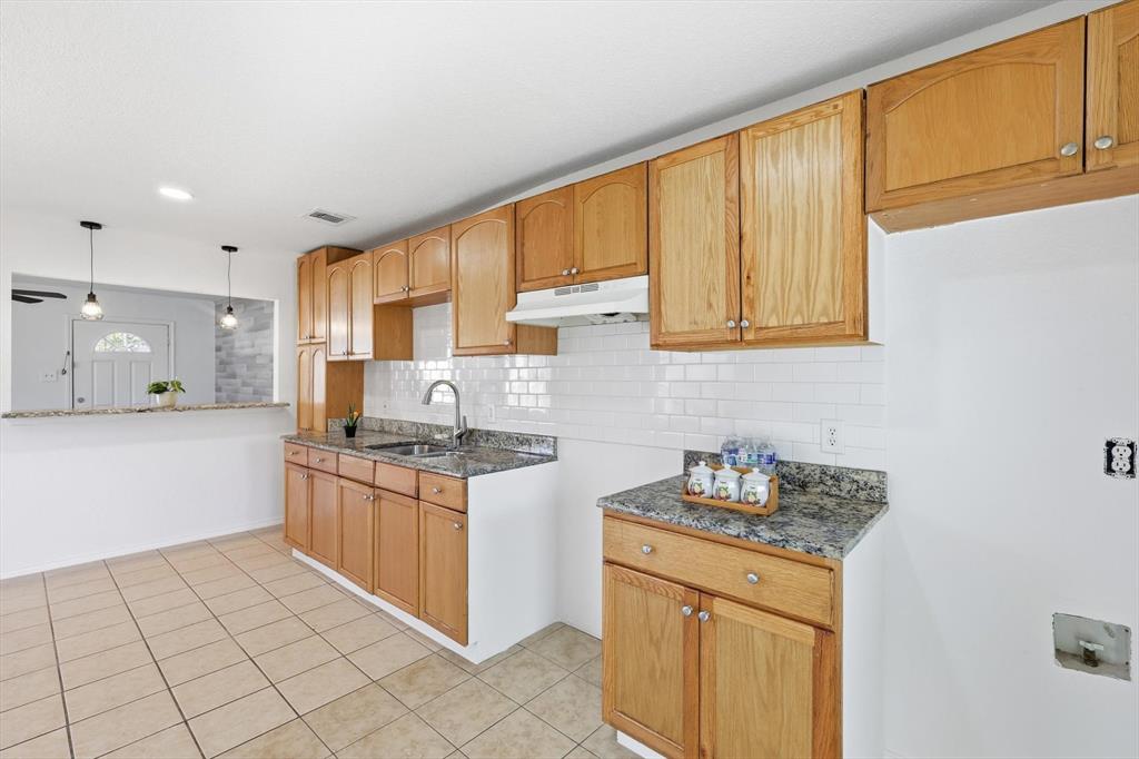 4024 Moler Street Dallas, TX 75211 - Photo 11 of 27 a kitchen with stainless steel appliances granite countertop a stove a sink and a microwave
