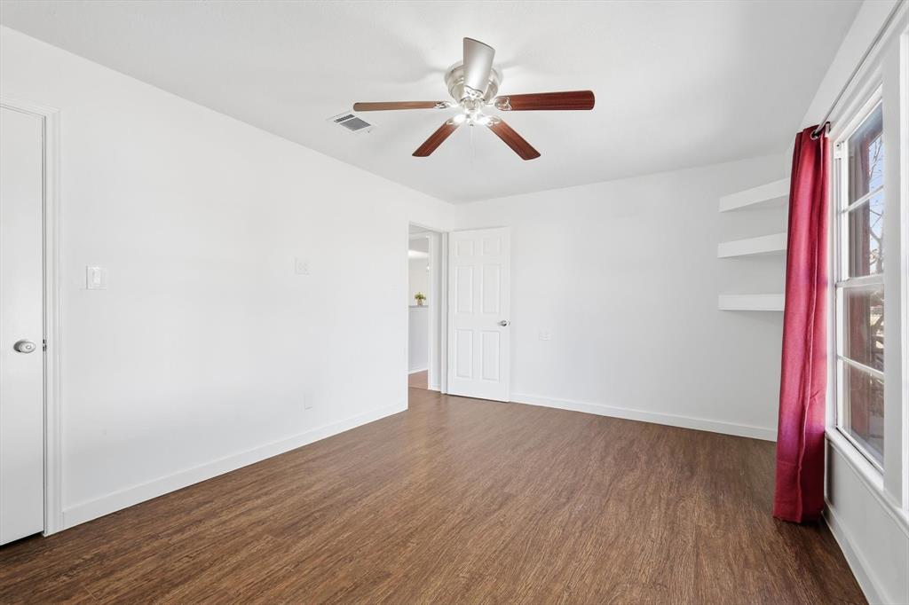 4024 Moler Street Dallas, TX 75211 - Photo 15 of 27 an empty room with wooden floor and a ceiling fan