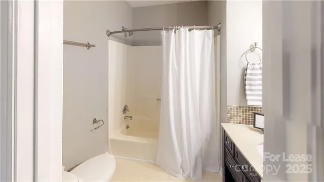 a bathroom with a shower curtain and a bath tub