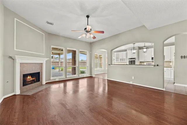 a view of an empty room with window and wooden floor
