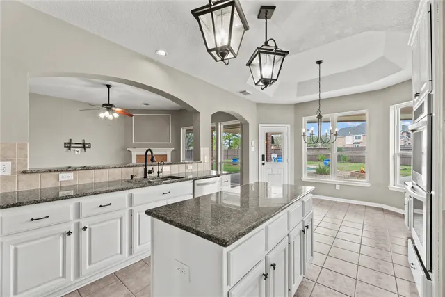 a large kitchen with kitchen island granite countertop a large window cabinets and stainless steel appliances