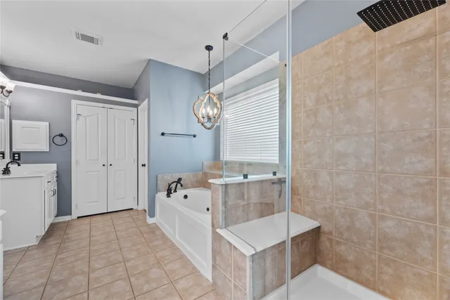 a view of a livingroom with a chandelier fan and windows