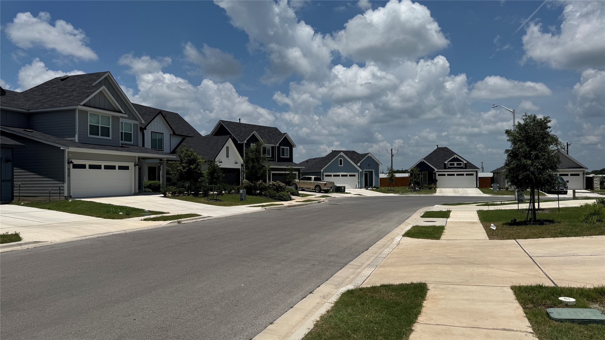 408 Frogmore Loop Kyle, TX 78640 - Photo 3 of 32 A quiet residential street showcases modern homes with appealing architectural variations.