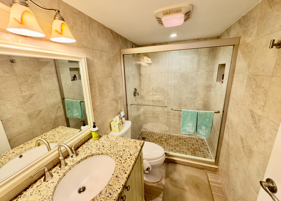 420 Celestial Way, Unit 403 Juno Beach, FL 33408 - Photo 15 of 25 a bathroom with a granite countertop sink mirror vanity and bathtub