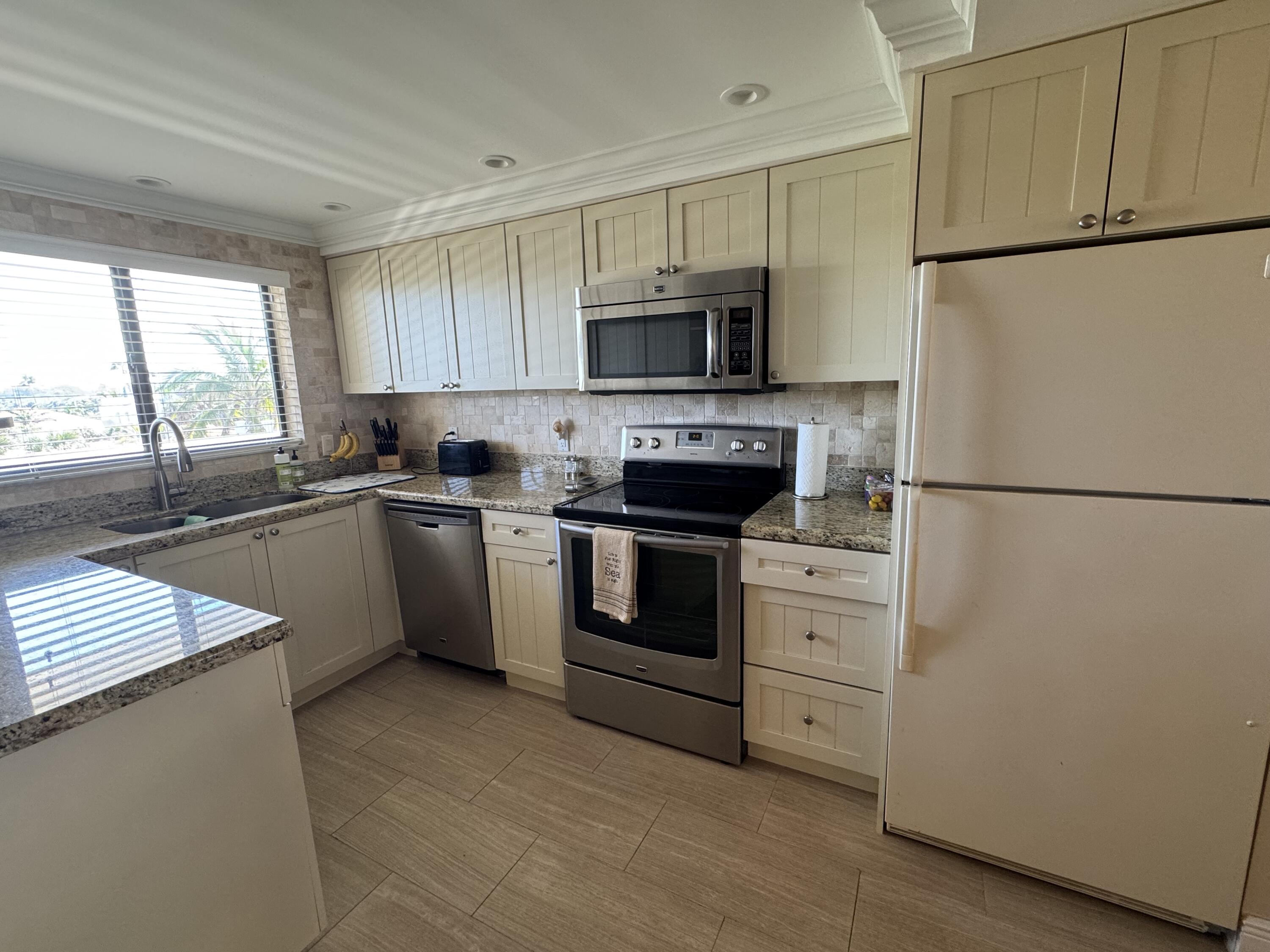 420 Celestial Way, Unit 403 Juno Beach, FL 33408 - Photo 21 of 25 a kitchen with stainless steel appliances white cabinets and a sink
