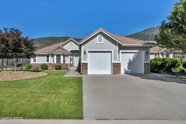 a front view of a house with yard and green space