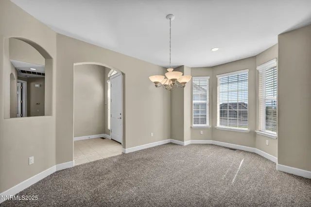 a view of a room with a chandelier fan and windows
